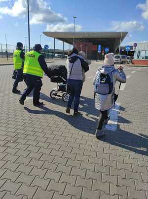 Policjanci pomagają ludziom uciekającym przed wojną