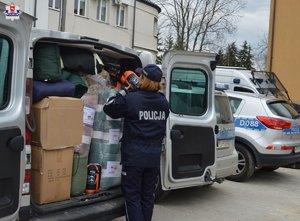 Policjantka przy busie pełnym darów rzeczowych dla policjantów we Lwowie