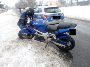 motocykl koloru niebieskiego marki suzuki oraz oznakowany policyjny radiowóz