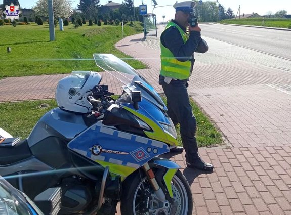 policjant ruchu drogowego stoi przy motocyklu
