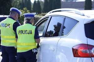 Policjanci w kamizelkach odblaskowych podczas kontroli drogowej