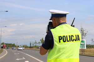 Policjant ruchu drogowego mierzy prędkość kierującym