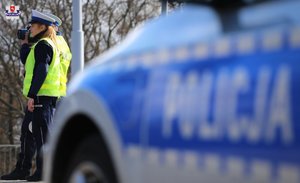 policjanci stoją obok radiowozu