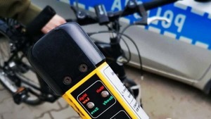 policyjny radiowóz, rower oraz urządzenie do pomiaru stanu trzeźwości