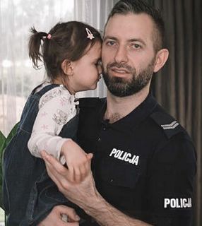 Policjant z dzieckiem na ręku