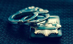 kajdanki leżące obok odznaki policyjnej