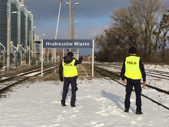 Zdjęcie przedstawia dwóch umundurowanych policjantów, którzy kontrolują infrastrukturę kolejową
