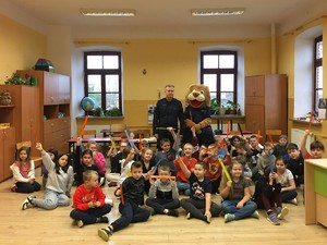 umundurowany policjant stoi w grupie dzieci