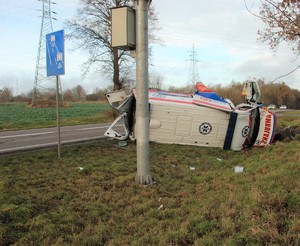 Zdjęcie przedstawia wywrócona na bok karetkę pogotowia ratunkowego, która uczestniczyła w wypadku drogowym