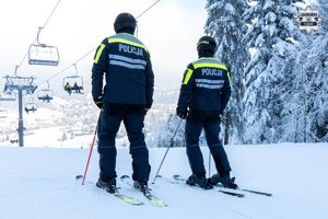umundurowani policjanci na nartach stoją na stoku