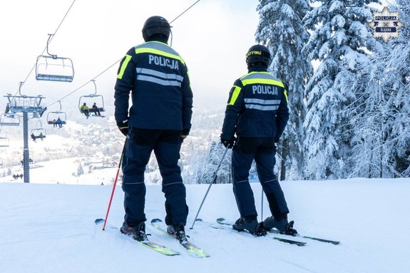 umundurowani policjanci na nartach stoją na stoku