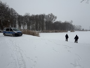 policjanci chodzą po zaśnieżonym terenie