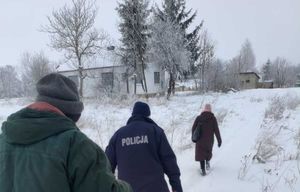 policjant z pracownikami opieki społecznej idzie przez zaśnieżoną ścieżkę do domu mieszkalnego