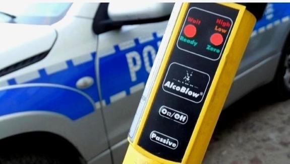 urządzenie służące do badania trzeźwości kierujących na tle radiowozu policyjnego