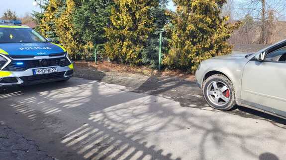 Policyjny radiowóz stoi obok zaparkowanego audi