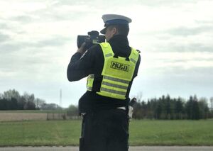 umundurowany policjant mierzy prędkość nadjeżdżających pojazdów