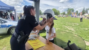 policjantka prezentująca dzieciom jak korzystać z numeru alarmowego 112