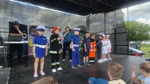 dzieci w strojach służb mundurowych stojące na scenie