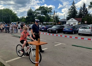 umundurowany policjant oraz chłopiec w trakcie egzaminu na kartę rowerową