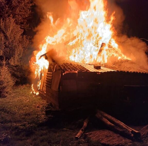 płonący budynek gospodarczy