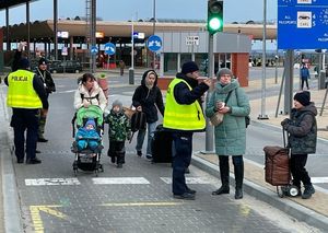 policjanci na przejściu granicznym pomagają uchodźcom