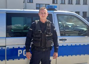 policjant stoi przez radiowozem typu bus